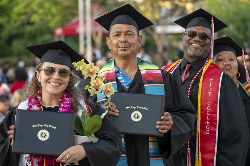 Diverse student graduates holding diploma