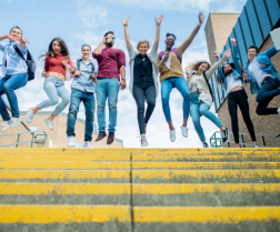 students jumping at top of stairs
