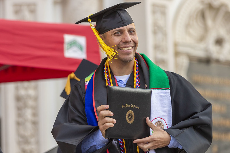 Male graduate holding diploma