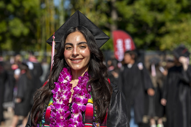 Woman with flower lei Woman smiling with cap and gown and flower lei
